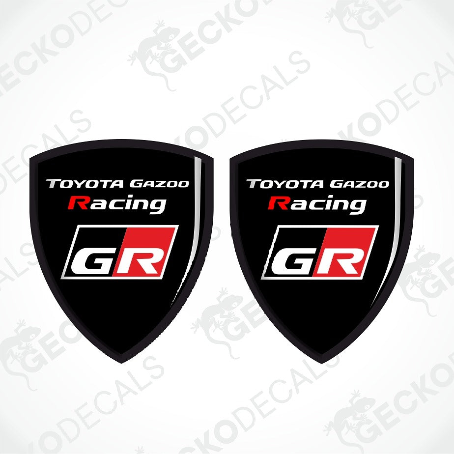 Two identical black shield-shaped decals with the Toyota Gazoo Racing GR logo, displayed side-by-side on a white background with faint watermarks.