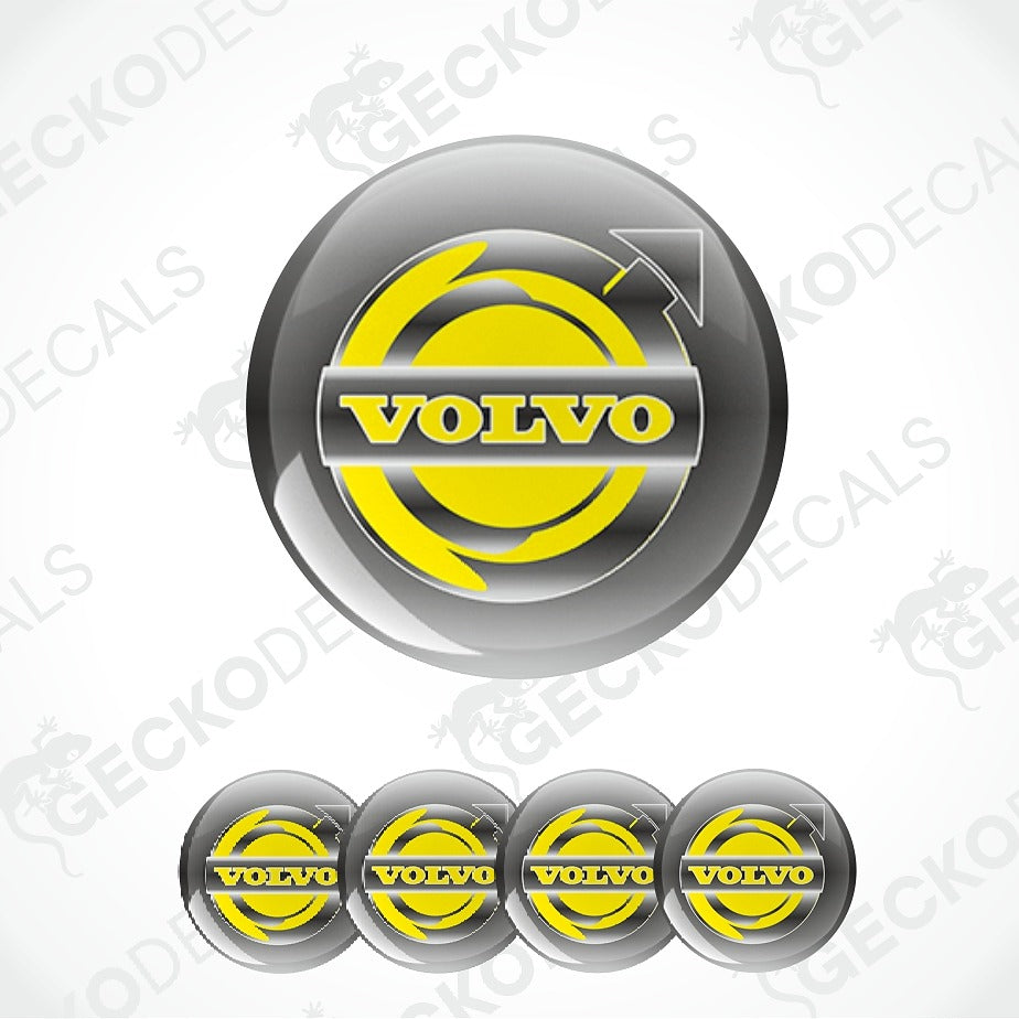 A glossy yellow and silver Volvo logo decal shown in a large circular format, with four smaller identical decals aligned along the bottom on a light gray background. Faint repeated 'GECKODE' watermarks are visible across the