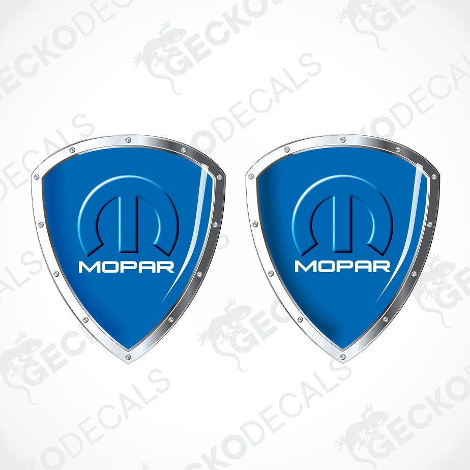 Two blue shield-shaped Mopar decals with silver borders and the Mopar logo, shown on a light gray background with diagonal watermark text.