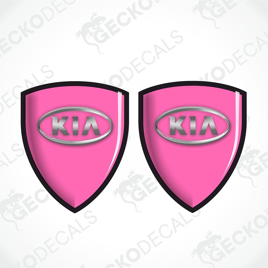 Two pink shield-shaped Kia decal stickers with black borders and silver Kia logos, shown on a white background with faint watermarks.