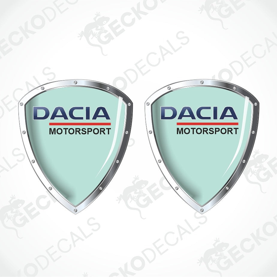 Two identical Dacia Motorsport shield-shaped decals on a white background with diagonal watermarks. The decals feature a light mint green center, silver metallic borders, and the Dacia Motorsport logo in blue and red.