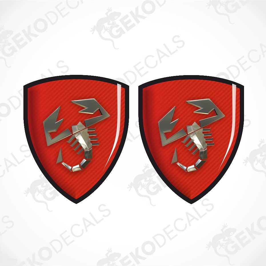 Two identical red shield-shaped decals with a black border and a silver scorpion emblem, shown on a white background with diagonal watermark text.