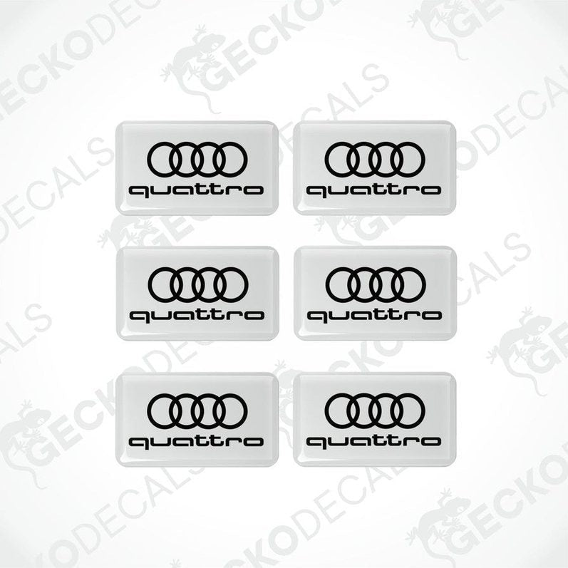 A set of white vinyl decals with the 'quattro' logo printed in white.