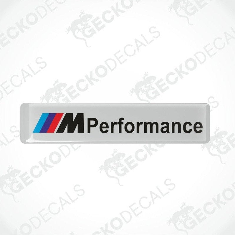 Rectangular white vinyl decals with 'M Performance' text and the BMW logo in red, blue, and black.