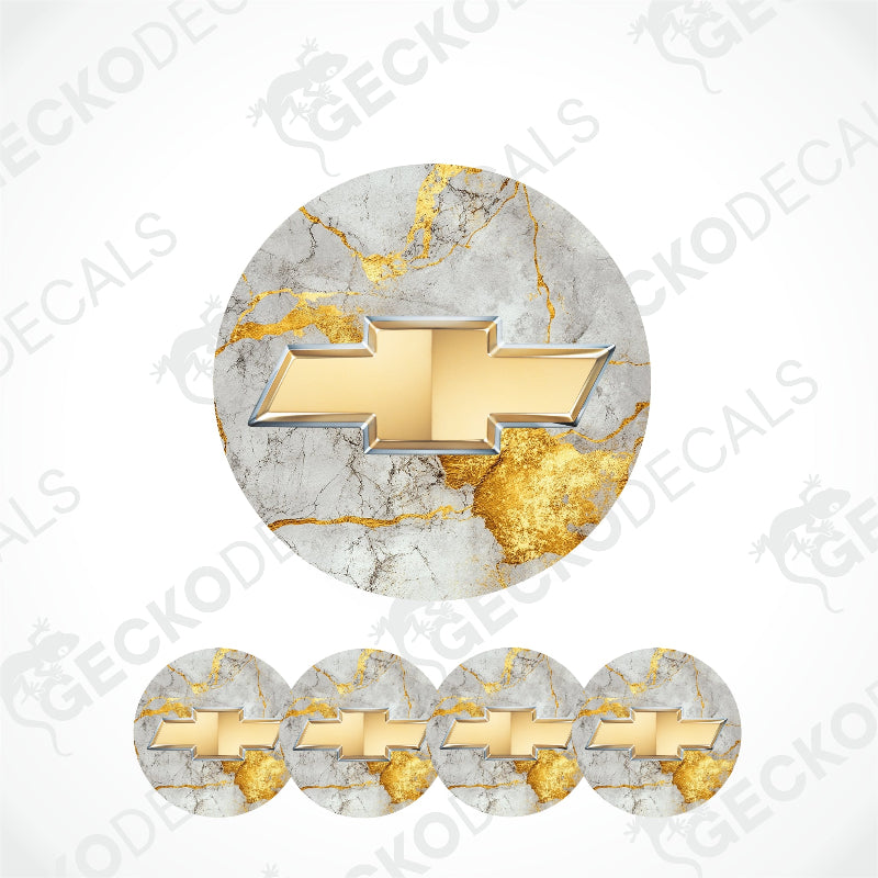 A gold metallic Chevrolet logo with a thin silver border on a golden light gray marble background.