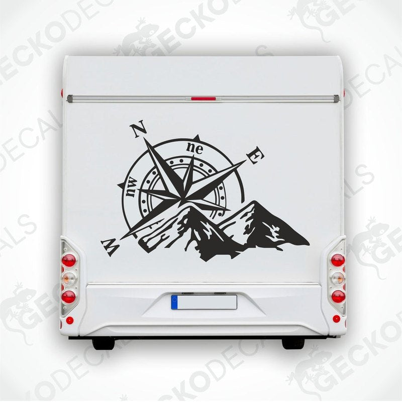 Black Compass Mountain RV decal applied to rear door showing directional markers and rugged peaks