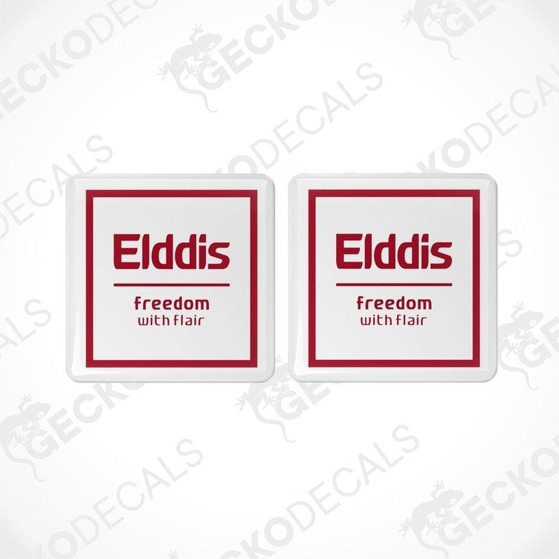 Two white vinyl stickers with red and black text, including the word 'ELDDIS' and the slogan 'Freedom with Flair'. There is a graphic of a caravan on the stickers.