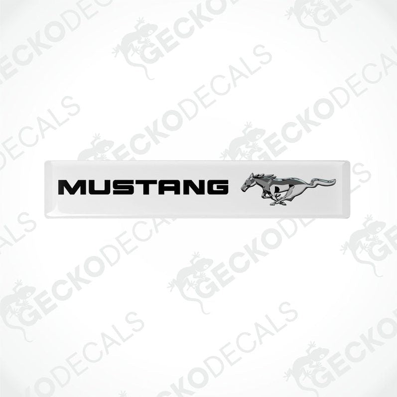 White vinyl stickers with the word 'MUSTANG' and an image of a horse and rider on them, placed against a white background.