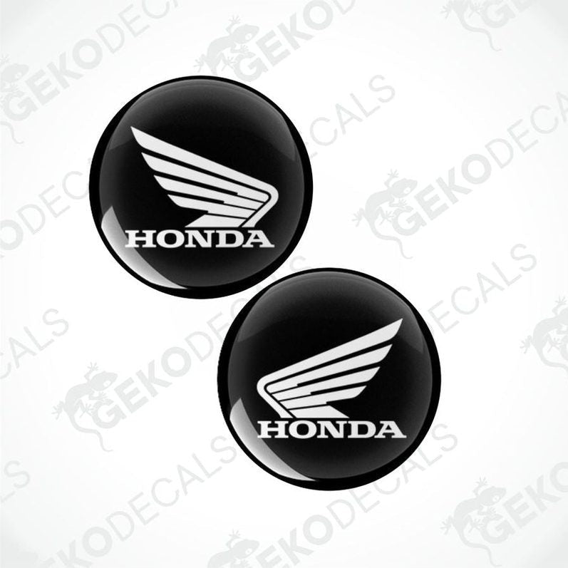 Two black Honda logos with wings on a white background.