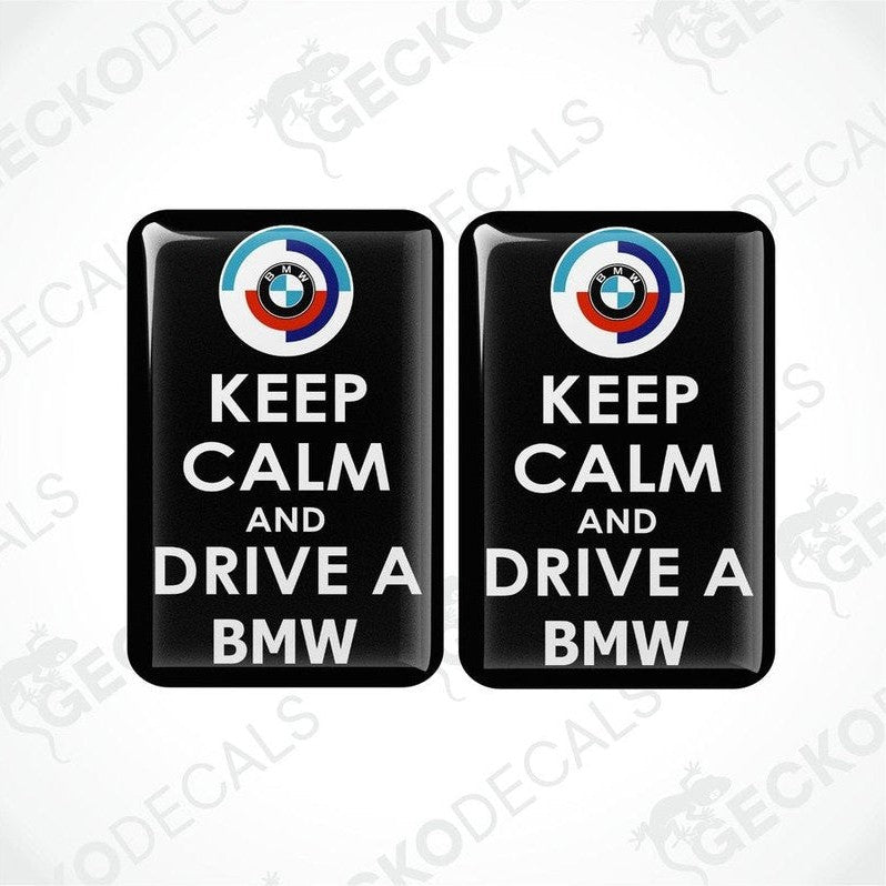 Two black vinyl stickers with the text 'KEEP CALM AND DRIVE A BMW' and the BMW logo.