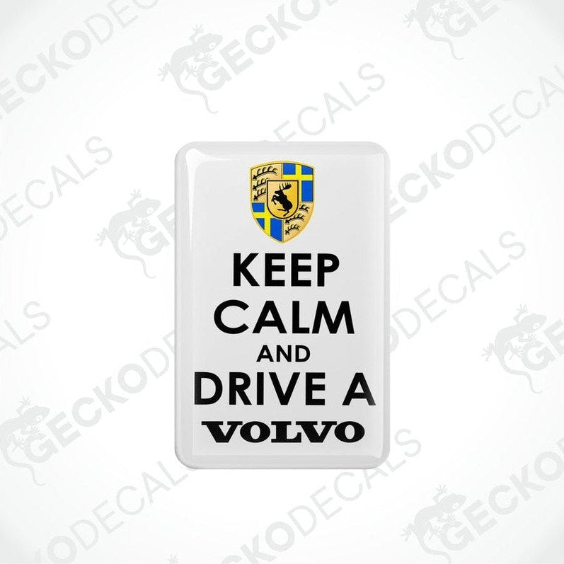 Rectangular withe vinyl decals with the text 'KEEP CALM AND DRIVE A VOLVO' in white letters, and the Volvo car logo in yellow and blue.