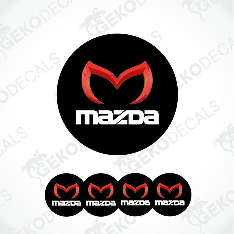A set of four black vinyl stickers with a red and white MAZDA logo, designed for use on car wheels.