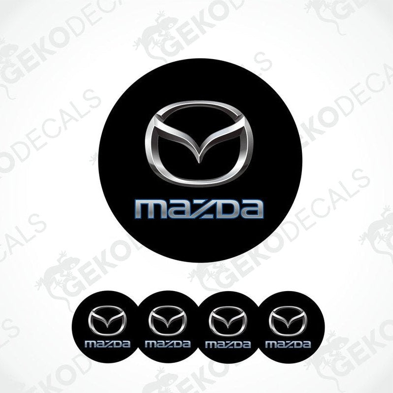 A set of black round car decals with the Mazda logo in the center and smaller copies of the logo on the sides.