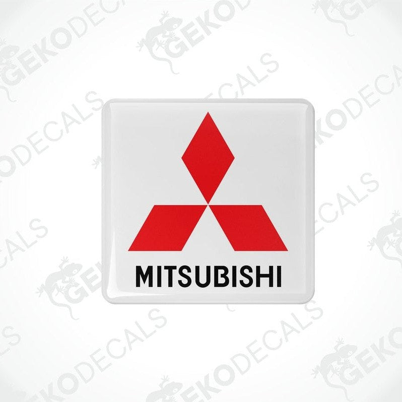 White vinyl stickers with a red Mitsubishi logo on each, placed against a black background with the text 'MITSUBISHI' below each sticker.