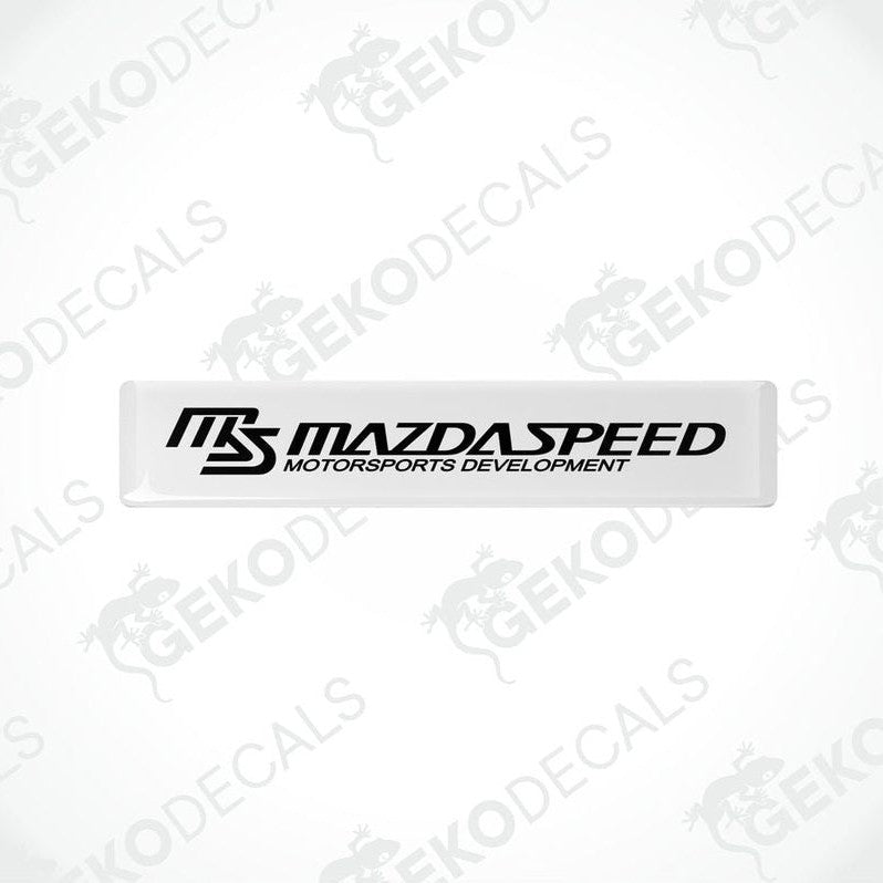 White and black rectangular decals with 'MAZDASPEED MOTORSPORTS DEVELOPMENT' text.