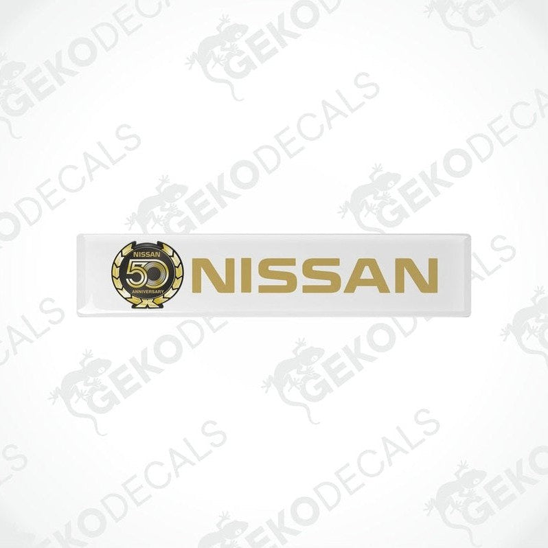 White vinyl stickers with gold and gold text and graphics representing the NISSAN brand, placed against a white background.