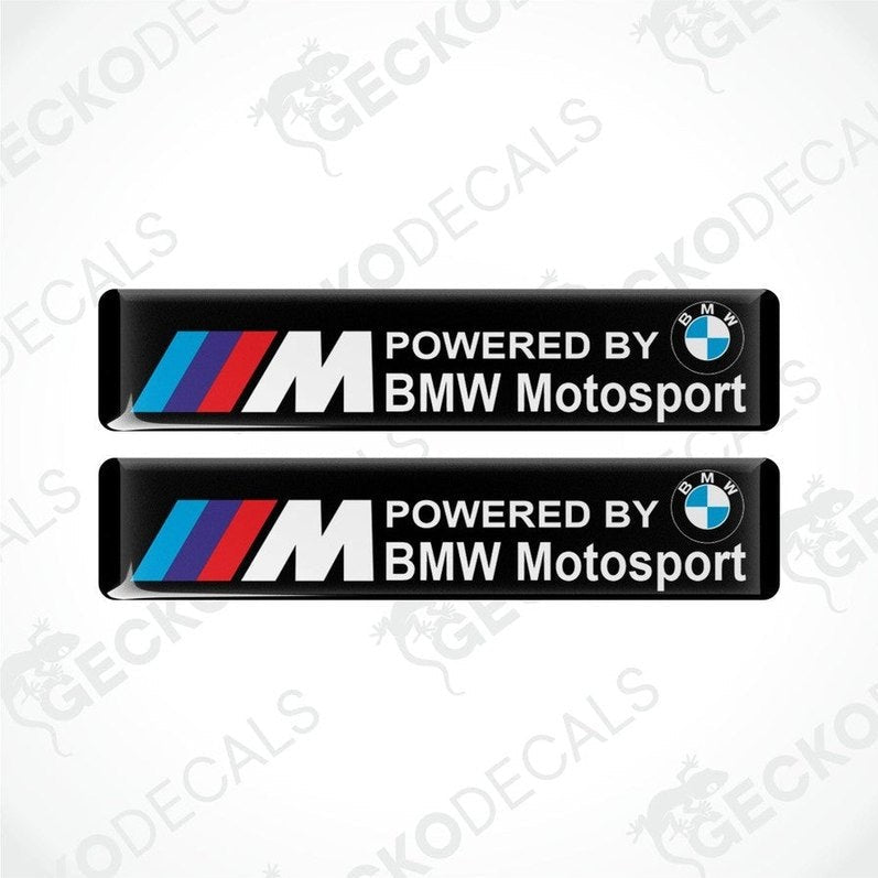 Two black vinyl stickers with the text 'POWERED BY BMW MOTOSPORT' and the BMW logo in red, white, and purple.
