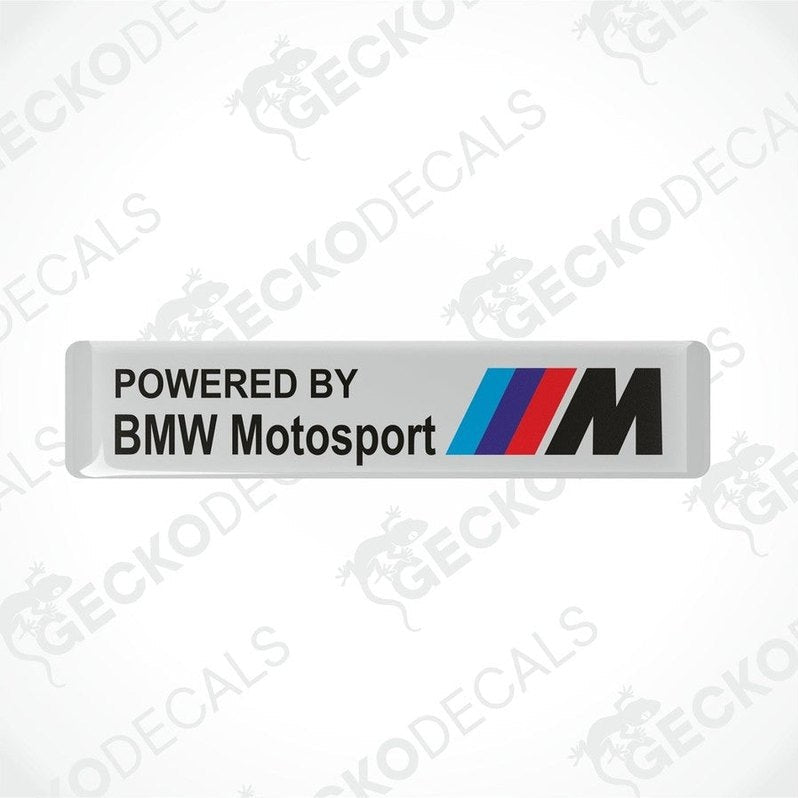 White vinyl stickers with the text 'POWERED BY BMW MOTOSPORT M' and the BMW logo in black, red, and blue colors.