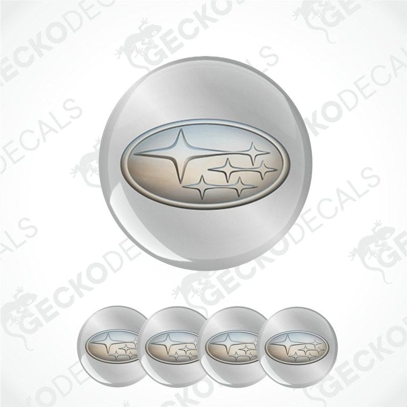 Set of four metallic Subaru logo emblems on a white background.