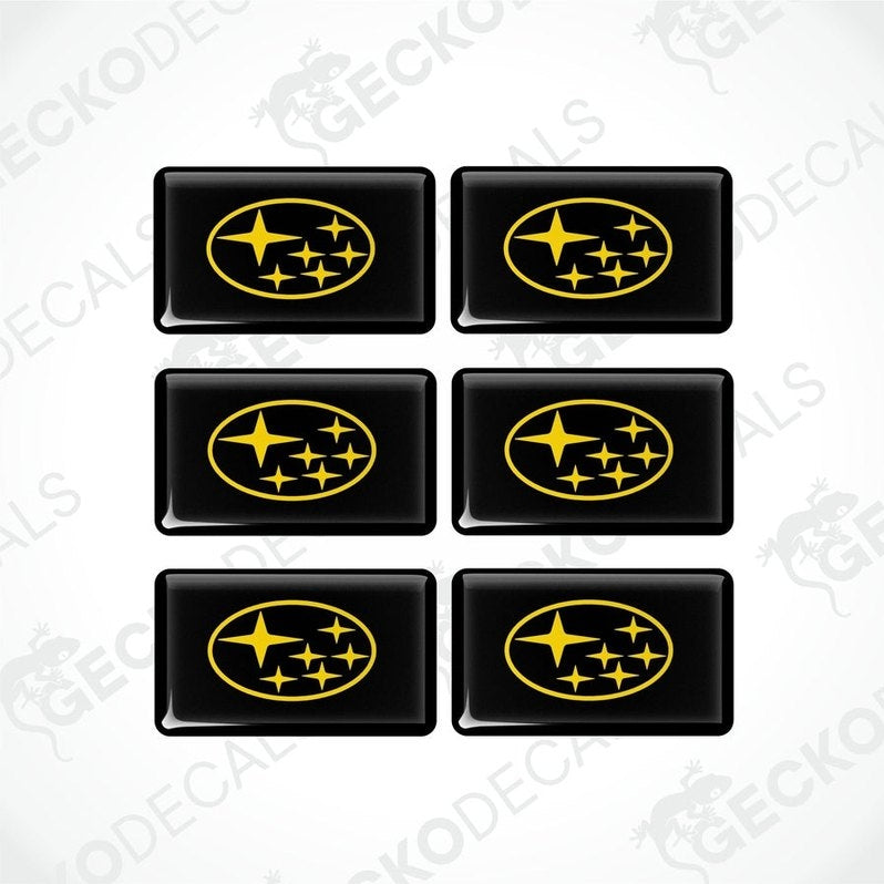 A set of six black and yellow, vehicle decals featuring the Subaru logo.