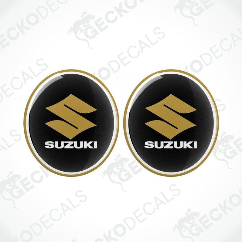 Two Suzuki logos on black background with gold outline