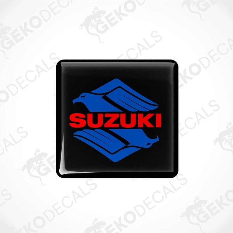 Black square stickers with the SUZUKI brand logo in blue and red.