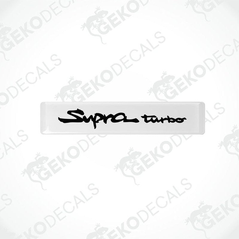 Withe vinyl decals with 'Supra turbo' text in black, indicating a set of car stickers for a Toyota Supra vehicle.