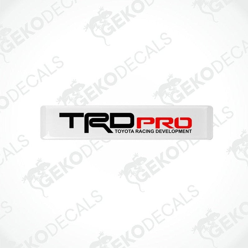 Withe vinyl stickers with red and black text 'TRD PRO' and 'TOYOTA RACING DEVELOPMENT', placed on a white background.