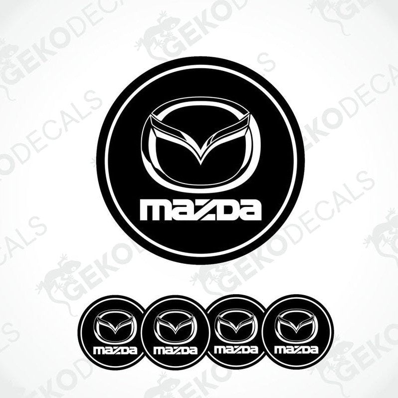 A set of black and white vinyl decals with the Mazda logo, including four different sizes shown against a white background.