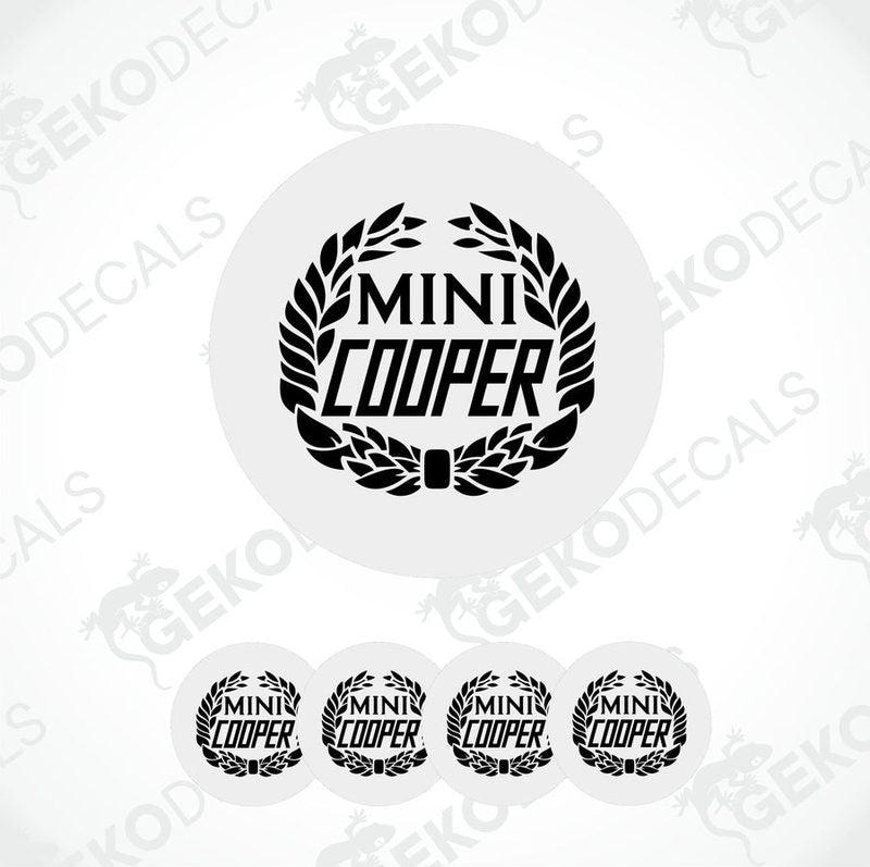 A set of four black and white vinyl decals with the text 'MINI COOPER' on them, presented against a white background