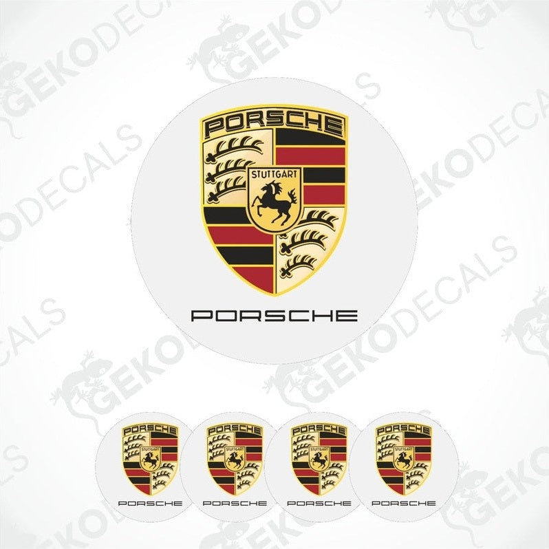 A set of four Porsche car wheel hub caps with the Porsche logo.