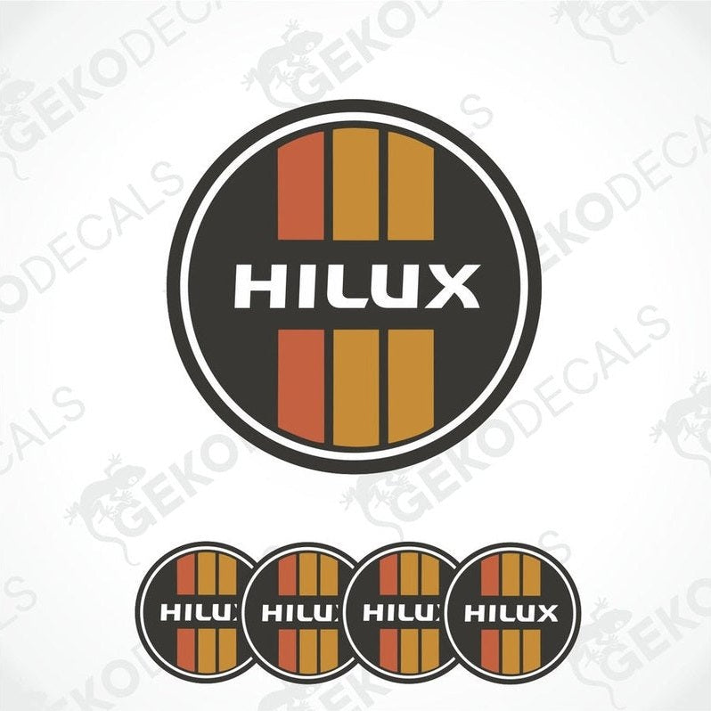 A set of four red, orange, and black vinyl stickers with the word 'HILUX' on them, arranged in a circular pattern with a white background.