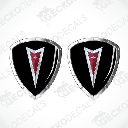 Two identical shield-shaped car decals with a black background, silver metallic borders, and a red chevron emblem with a white star, shown on a light gray background with a faint watermark pattern.