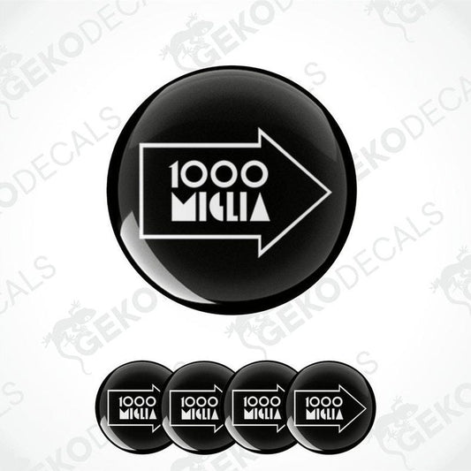 A set of black vinyl decals with the text '1000 MIGLIA' in white. The decals are designed to be applied on a surface, likely car wheels, to serve as decorative stickers.