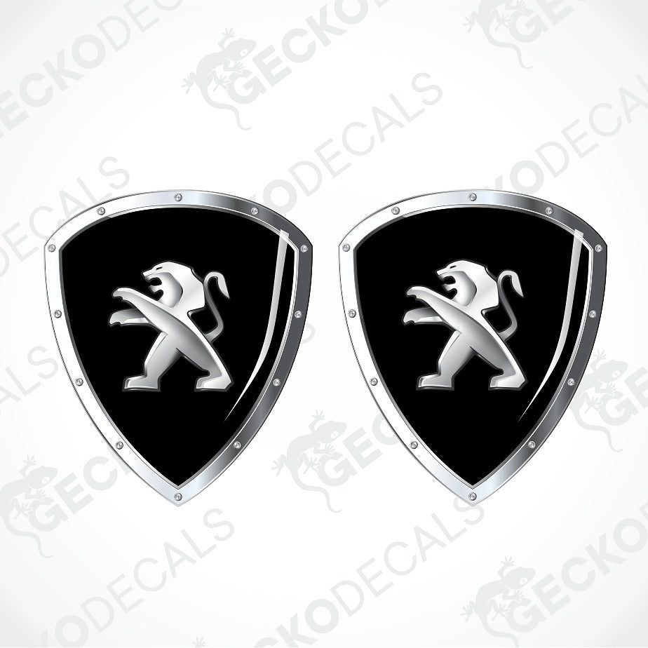 Two identical shield-shaped decals featuring the Peugeot lion logo in silver on a black background, with a chrome silver border and rivet details, shown on a light gray background with a faint watermark pattern.