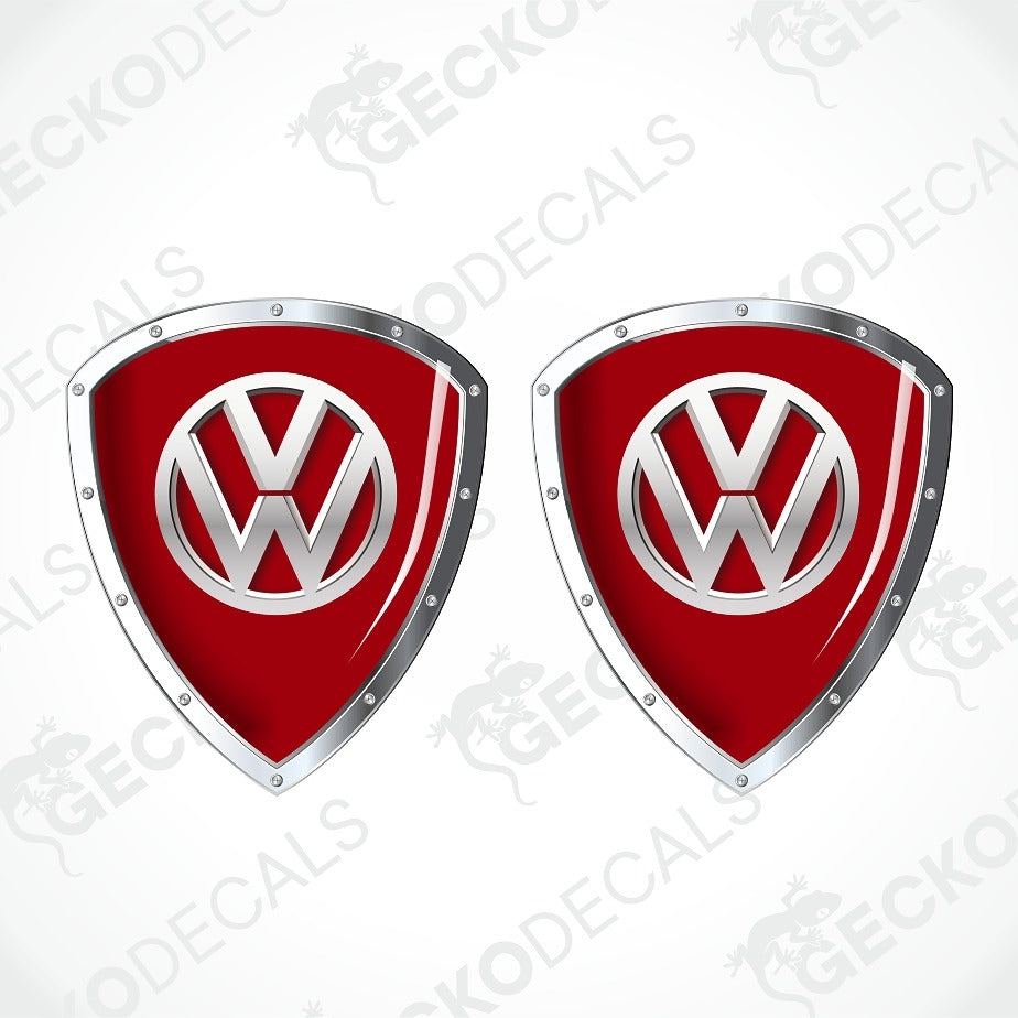 Two red and silver Volkswagen shield-shaped decals on a light gray background with faint Geekodec watermarks.