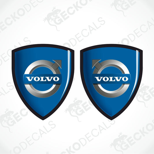 Two blue Volvo shield-shaped decals with the Volvo logo in the center, shown on a light gray background with faint watermark text.