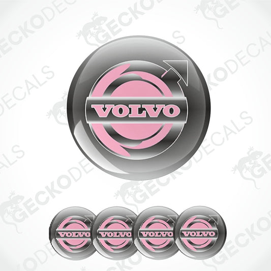 A glossy circular Volvo logo decal shown prominently, with four smaller identical decals aligned along the bottom on a light gray background. The logo features a pink circular emblem with a silver-gray arrow and the word VOLVO in white.