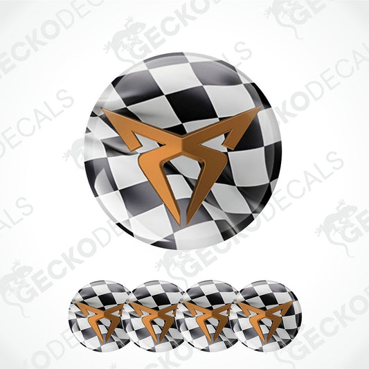 A circular decal or badge design featuring a black-and-white checkerboard pattern with a metallic gold stylized emblem in the center, shown on a white background with four smaller repeated views along the bottom.