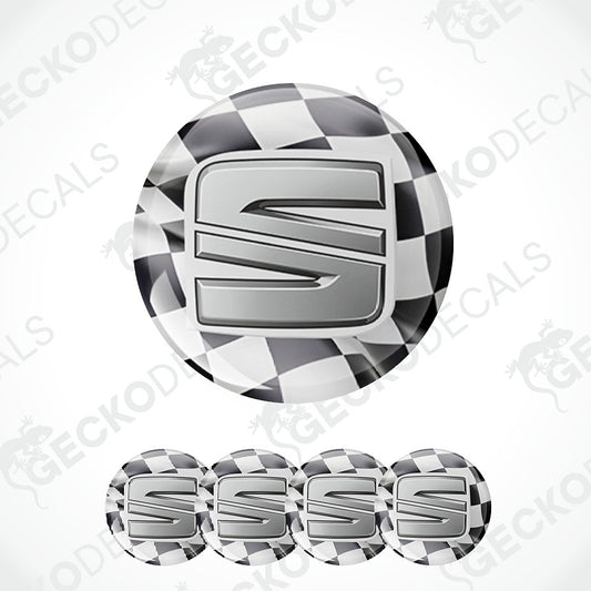 A circular decal or emblem featuring a large metallic silver letter 'S' over a black-and-white checkered flag pattern, shown on a white background with four smaller repeated versions along the bottom.