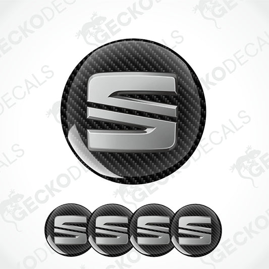A set of circular car emblem badges featuring a stylized silver 'S' logo on a black carbon fiber textured background, with one large badge and four smaller overlapping badges below, shown on a white background with faint Geekod watermarks.