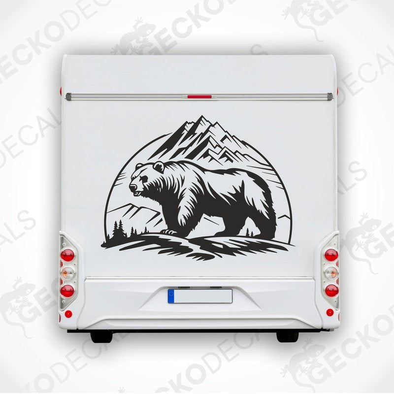 A black decal of a bear in front of mountains on a white surface.