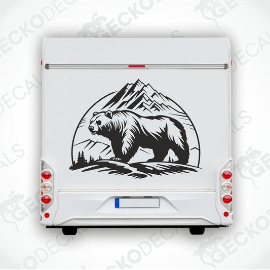 A black decal of a bear in front of mountains on a white surface.