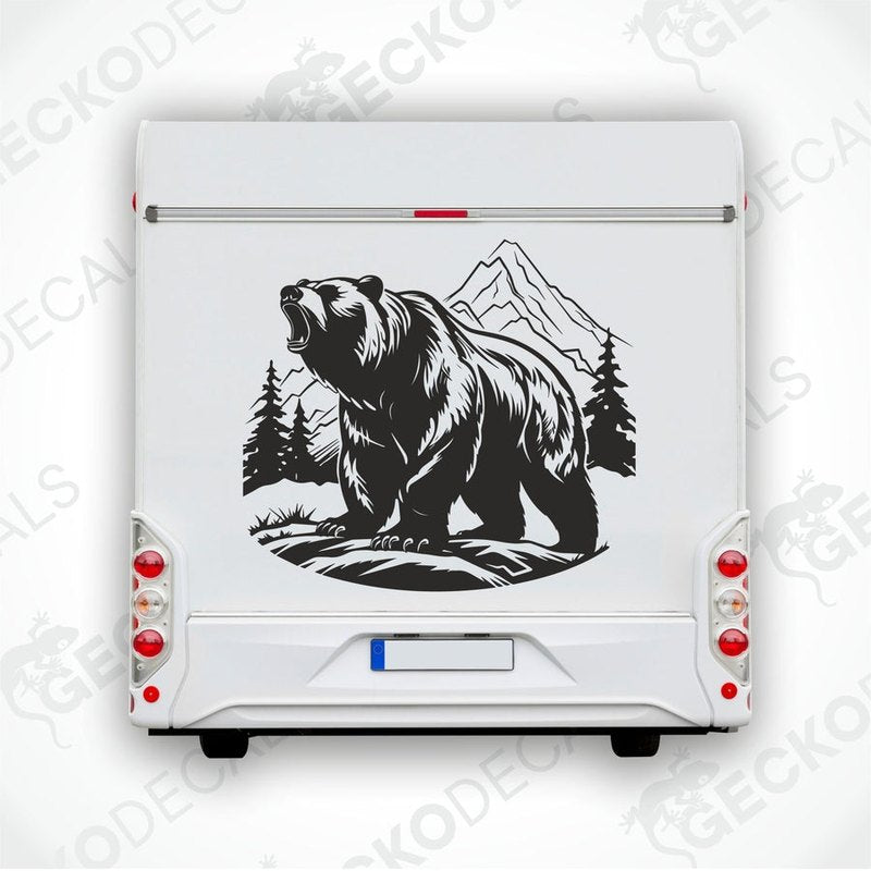 A decal of a bear in a mountain nature scene, positioned on the side of a white vehicle.