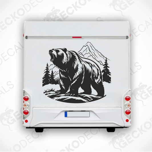 A decal of a bear in a mountain nature scene, positioned on the side of a white vehicle.