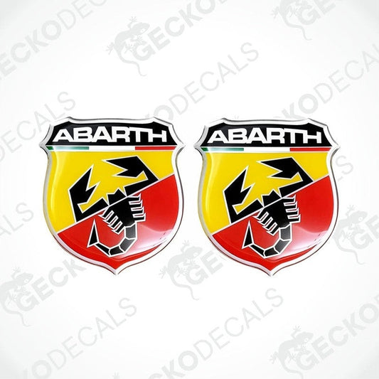A set of two vinyl stickers with a multicolored design featuring the word 'ABARTH' and a graphical element resembling a shield or a club.