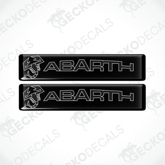 Two black vinyl stickers with the word 'ABARTH' written in white. Each sticker has a white graphic of a bird above the text.