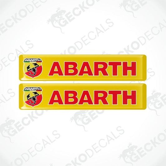 Two yellow vinyl stickers with the word 'ABARTH' written in red and green, positioned against a white background with the GeckoDecals logo.