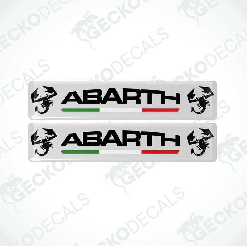 Two white vinyl decals with 'ABARTH' branding and Italian flag colors visible through the clear dome part.

