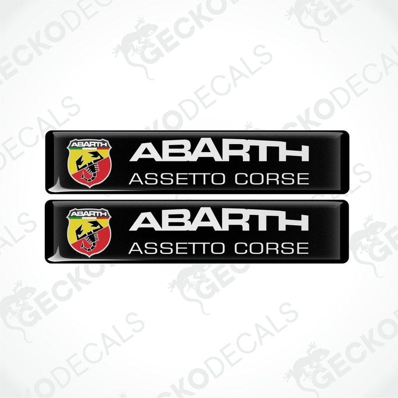 Two black rectangular vinyl decals with 'ABARTH ASSETTO CORSE' text and Abarth logo in red and yellow.
